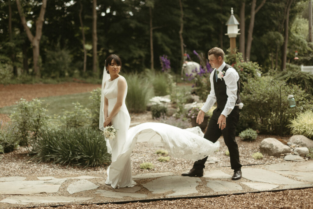 Photo of the groom fixing the brides dress. Editorial Styled Wedding Photo. Fine Art Wedding Photographer in Michigan 