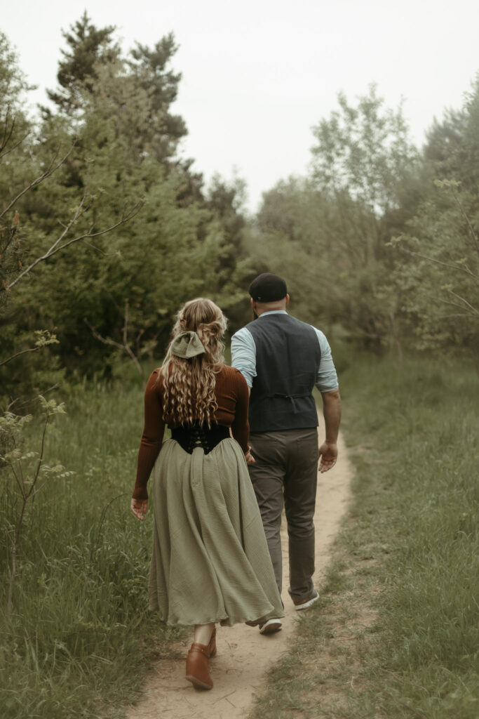 a man and a woman walking down a path in a cottagecore skirt in Kalamazoo michigan