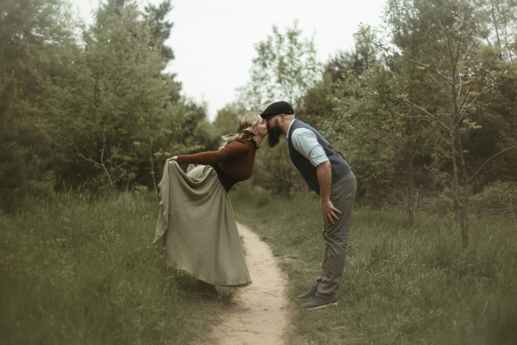A man and a woman kissing while she holds her skirt