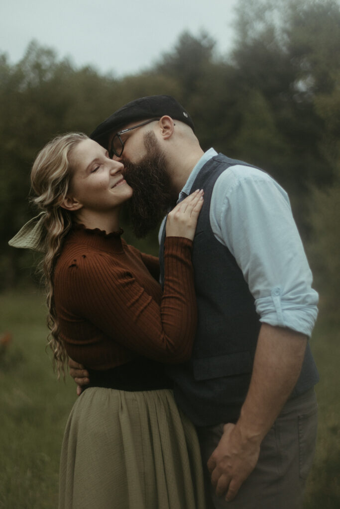 A man giving a woman a kiss for her engagement session in Michigan