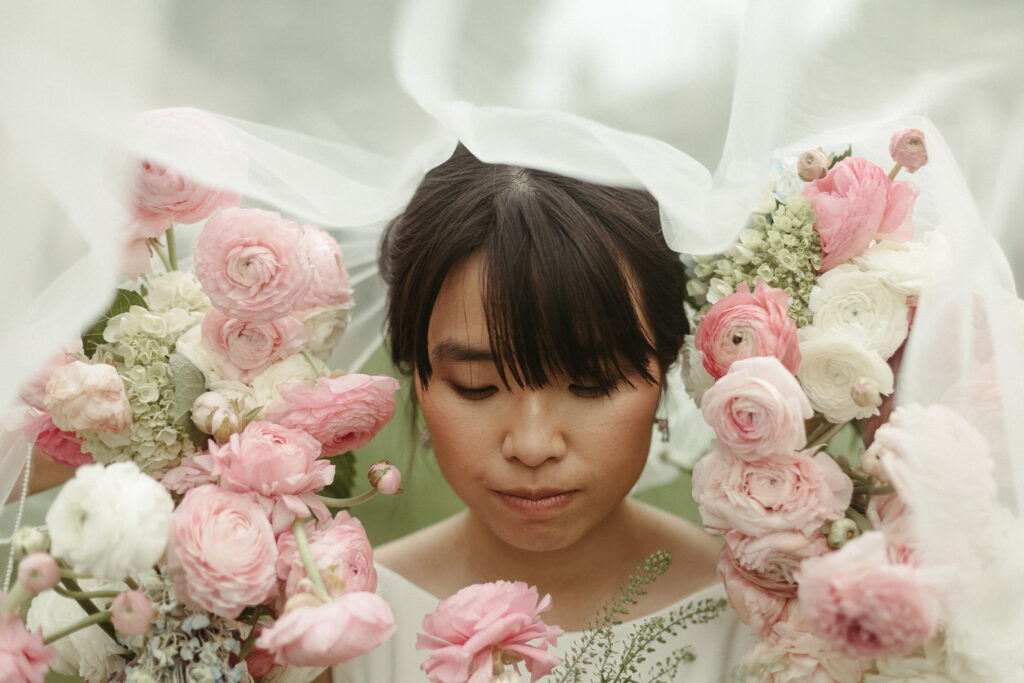 Editorial styled bridal portraits of the bride with peony's around her face. Editorial Styled Wedding Photo. Fine Art Wedding Photographer in Michigan 