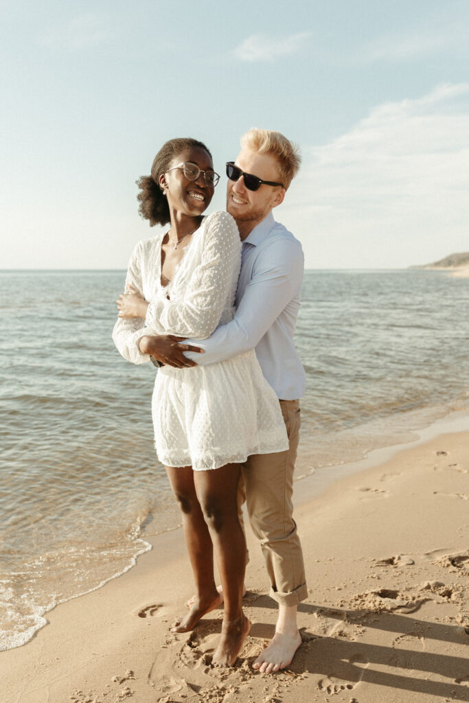 A man and a woman playing on the Lake Michigan beach together in Saugatuck Michigan