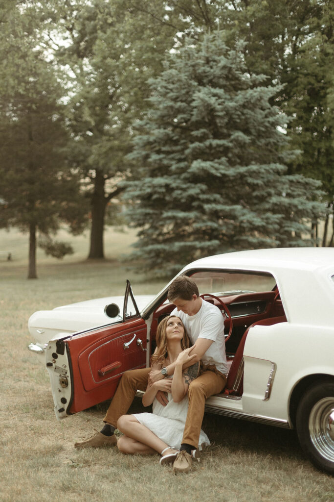 A man and a women running to a vintage car doing their engagement photos in Michigan