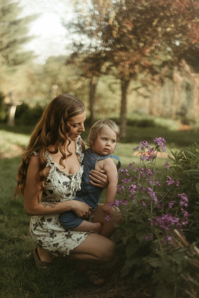 Photos of a woman and her son playing in a garden style wedding venue for their family photos.