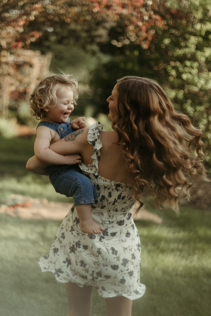 Photos of a woman and her son playing in a garden style wedding venue for their family photos.
