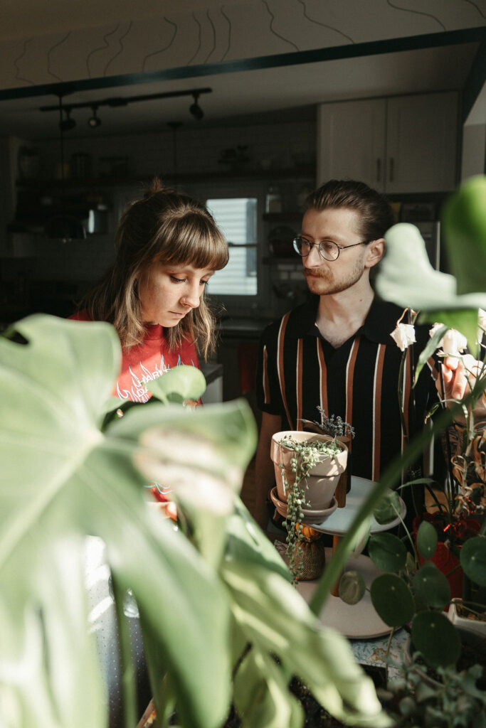 a detail photo of a man and a woman watering house plants