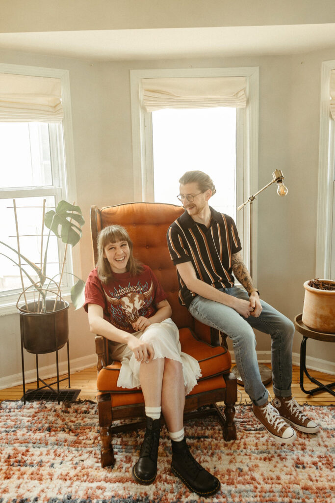 A man and a woman sitting in a vintage furniture in their home in downtown Grand Rapids michigan