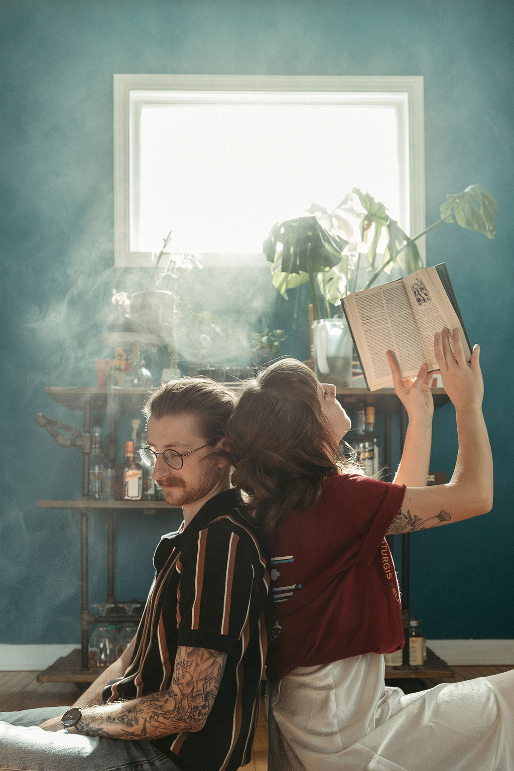 A man and a women in their house reading a book together