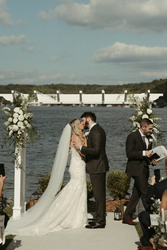 a man and a woman getting married on the lakeshore at Bay Pointe Inn in Shelbyville Michigan