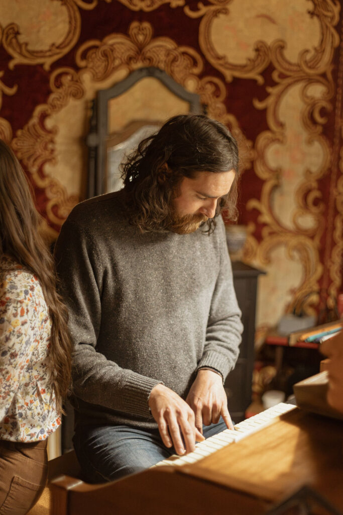 A man and a woman playing music together in a mid century styled air bnb