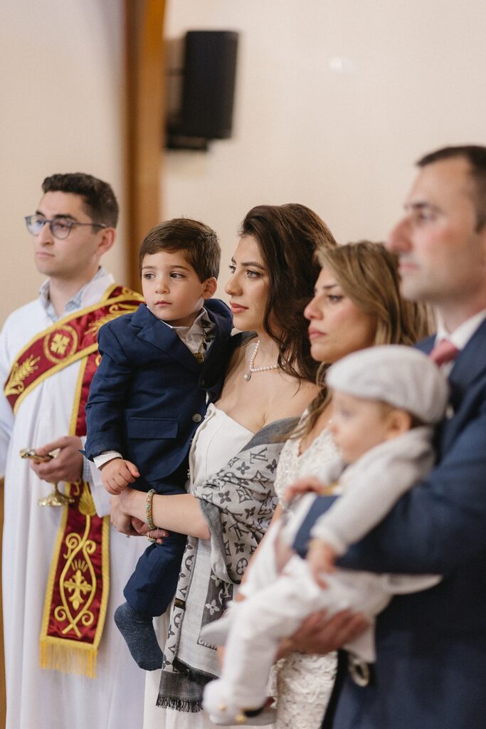 Baptism ceremony at Sts. Peter and Paul Syriac Orthodox Church in Southfield, Michigan with family gathered in prayer